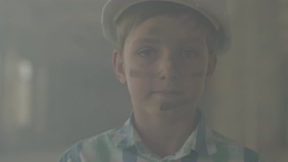 Portrait Teen Boy in a Protective Helmet Looking at the Camera in the Background of Smoke Indoors