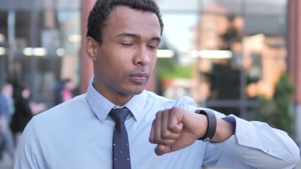 Waiting African Businessman Checking Time on Watch