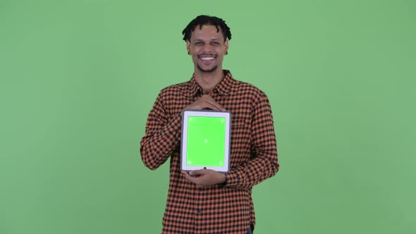 Happy Young Handsome African Man Talking While Showing Digital Tablet
