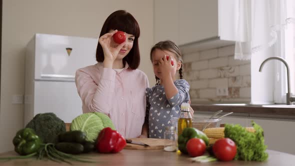 Caucasian Mother Sit at Kitchen Table with Little Cute Preschooler Daughter Teach Cooking Salad