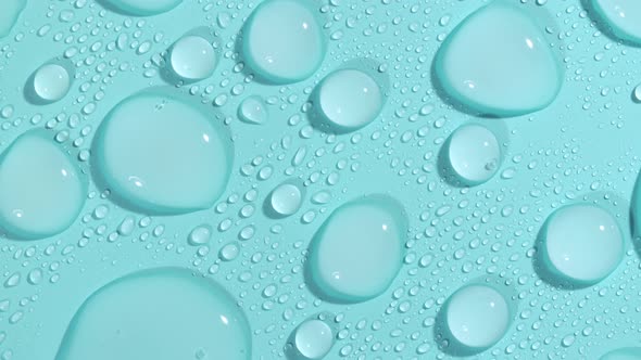 Macro Shot of Cosmetic Moisturizing Drops of Liquid on a Greenblue Pastel Background