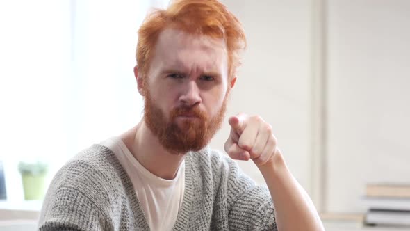 Man with Red Hairs Pointing Toward Camera