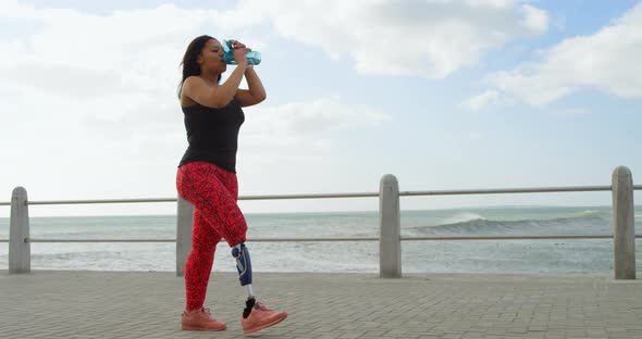 Side view of disabled woman drinking water on promenade 4k