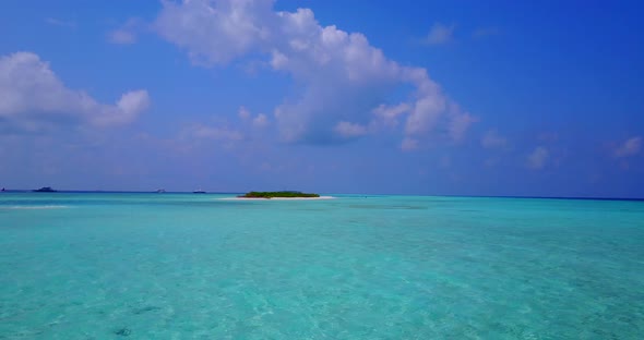 Tropical drone tourism shot of a sandy white paradise beach and aqua blue water background in 4K