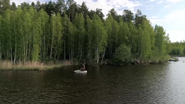 Aerial view of lake with equipped fishing piers and two fishermens in a boat fishing. 07