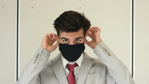 worried-looking young manager wearing mask staring at camera