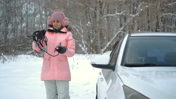 Confused Woman with Starter Cables By the Car