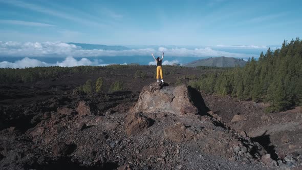 Young Woman Tourist Climbed to the Top of a Volcanic Stone