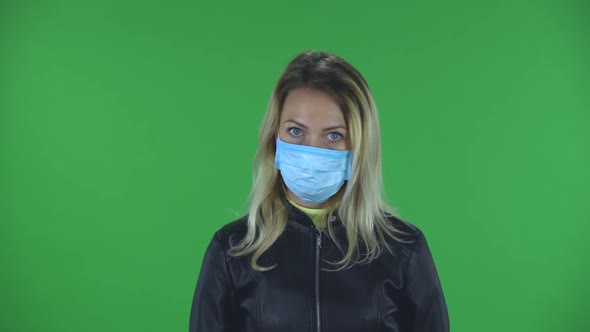 Portrait of Beautiful Young Upset Woman in Medical Protective Face Mask Is Looking at Camera and