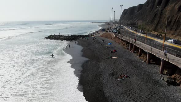 4k Daytime aerial video of the Pacific ocean hitting the cobblestone beach of Miraflores in Lima, Pe