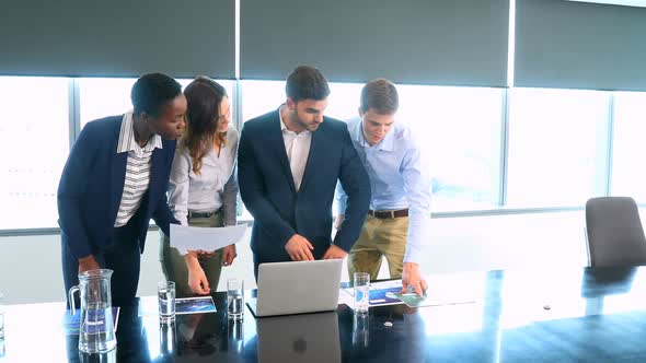 Business colleagues discussing over laptop and document 4k