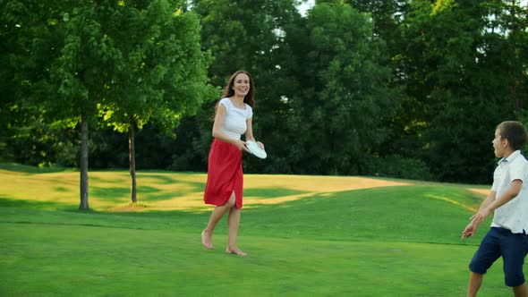 Parents and Children Playing Frisbee in Meadow. Family Throwing Frisbee Disc