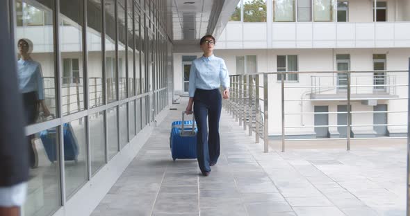 Businesswoman Dragging Suitcase Luggage Bag Walking to Passenger Boarding in Airport