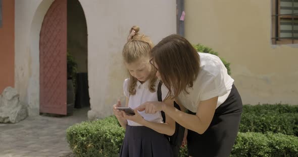 Mother and Daughter Relationship, Schoolgirl Using an Outdoor Phone with Mother