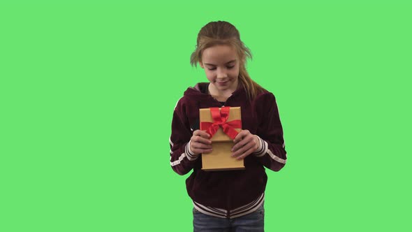 Portrait of Cheerful Teenage Girl Opening Gift Box, Making Surprised Face and Smiling at Camera
