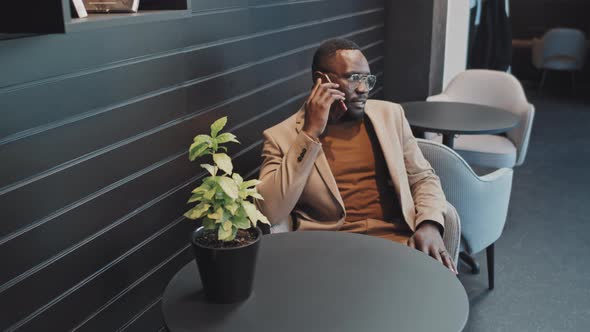 Businessman Making Phone Call in Cafe