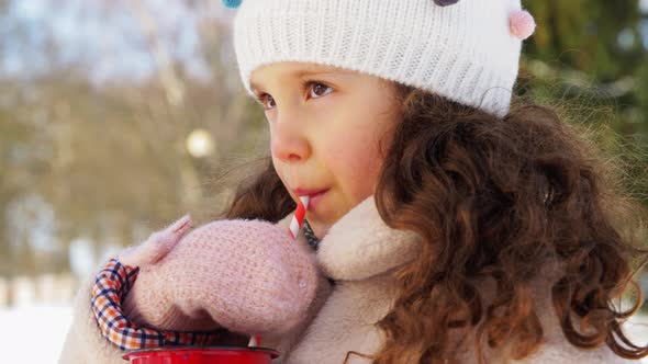 Little Girl Drinking Hot Tea in Winter Park