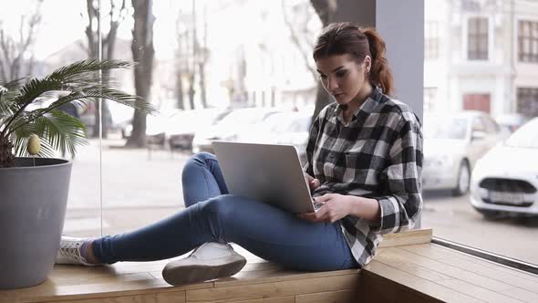 Beautiful Young Brunette Woman Working on Her Laptop