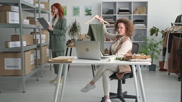 Young Businesswoman Owner of Fashion Boutique Sells Clothes Online By Video Link on a Laptop Against