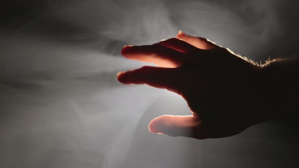 Male Hand in Backlight on Black Background