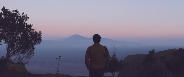 Man looks over mountainous landscape