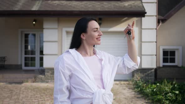Portrait of Caucasian Woman Admiring Keys From New House Looking at Camera Smiling