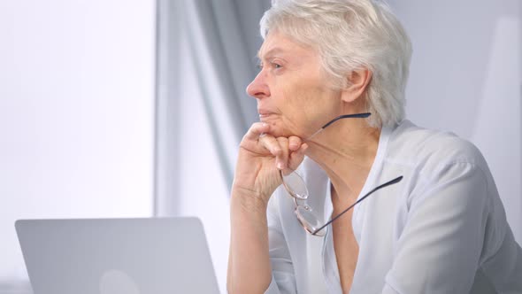 Corporate lady manager pensioner takes glasses off relaxing from work