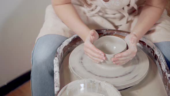 Woman Ceramist Is Creating Clay Bowl Using Potter's Wheel, Close-up