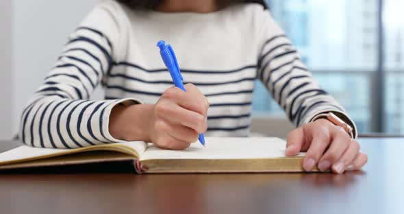 Woman write on the book at home