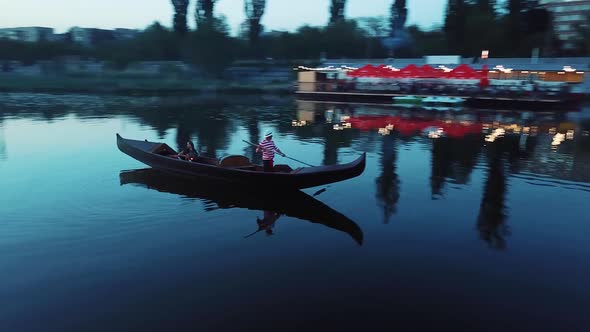 Young woman floating in a boat and holding lantern at night.