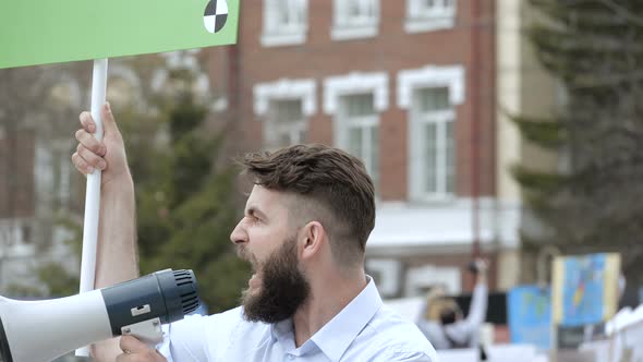 A Rebel on a Revolution Shouts Into a Megaphone Close-up in Slow Motion.