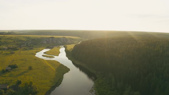 Aerial View of the River with a Rock and Forest on the Banks