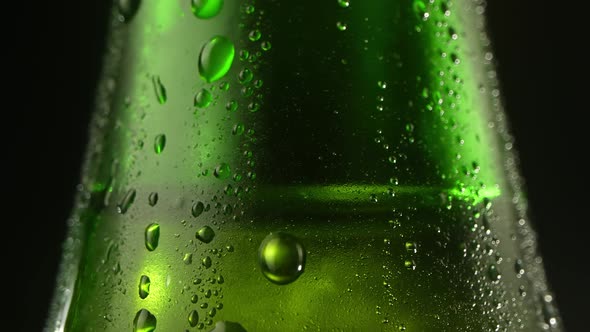 Drops of Condensate Drains on the Green Bottles of Beer