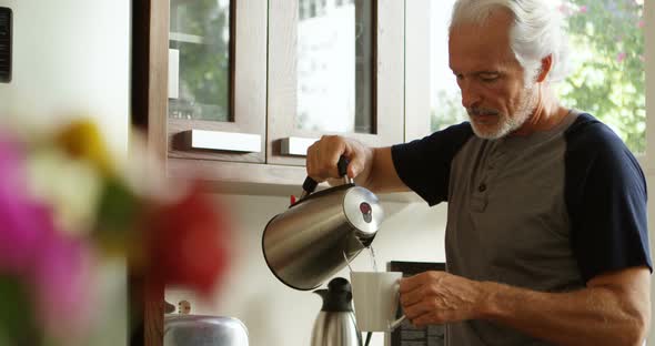 Senior man preparing coffee in kitchen 4k