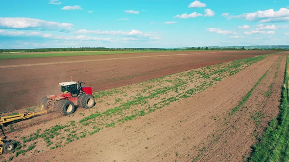 Plowing Tractor Works on Farm Field.