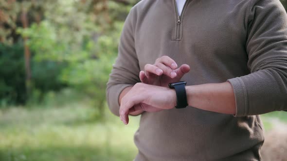 Tourist Asian Man Using Smartwatch in Forest Korean Student Use Smart Watch Application Trekking and