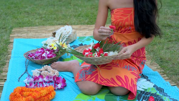 Young woman arranging flower on mat in the garden 4k