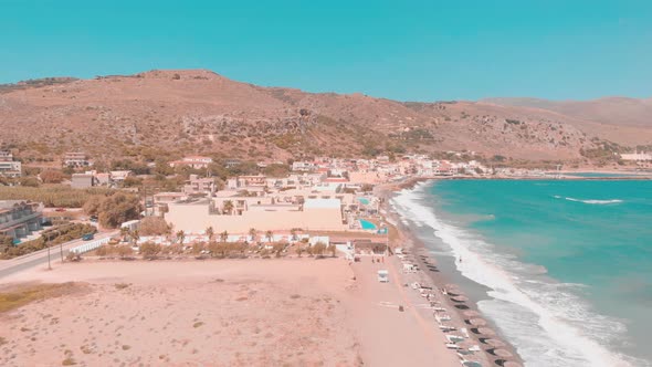 Drone flying up pointint to a small Greek town.