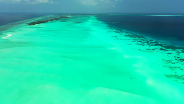 Aerial seascape of tranquil tourist beach journey by blue green sea with white sandy background of a