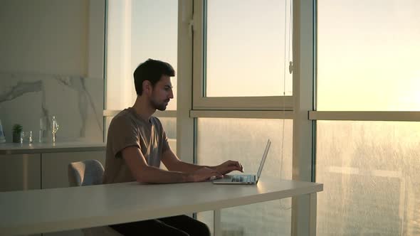 European Dark Haired Man Freelancer Opens Laptop for Work