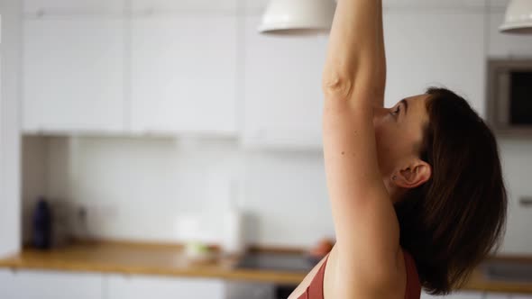 Woman at Home Doing Stretching Leans the Back