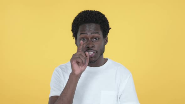 African Man Pointing at Camera Yellow Background