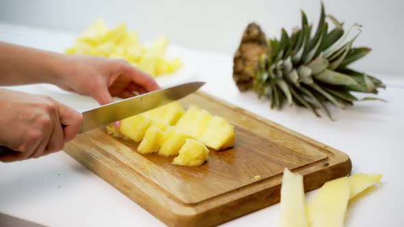 Board with delicious cut pineapple on table. Composition with fresh ripe pineapples on white backgro