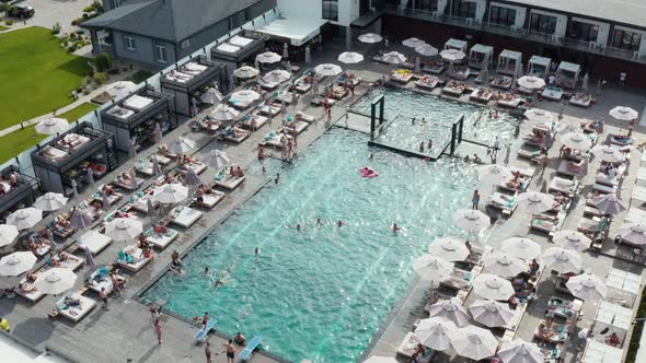 Aerial top view on swimming pool full of people having fun. 