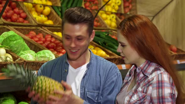 Couple Smells the Pineapple at the Hypermarket