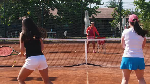 Tennis Coach Training Her Students on the Tennis Court