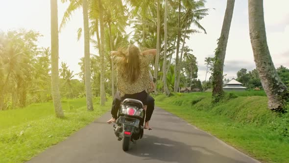 Happy Couple Tripping By Motorcycle on Tropical Road at Sunset Time. Outdoor Shot of Young Couple