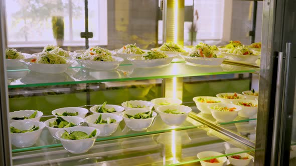 Showcase with Different Freshly Prepared Vegetable Salads in Self-service Cafeteria or Buffet