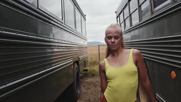 Dancing Woman In Yellow Between Busses