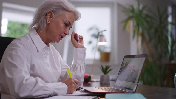 Side View Thoughtful Concentrated Caucasian Mature Woman Analyzing Business Profitability Sitting in